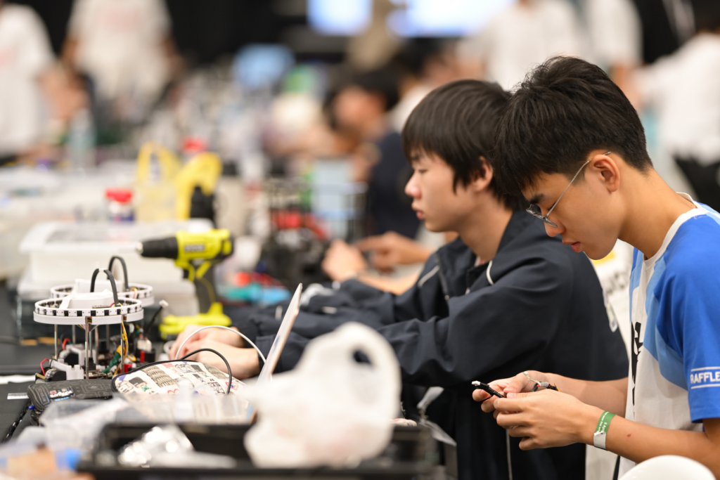 Raffles Institution students assembling RoboCup Junior Soccer robots at RoboCup Singapore Open 2025.