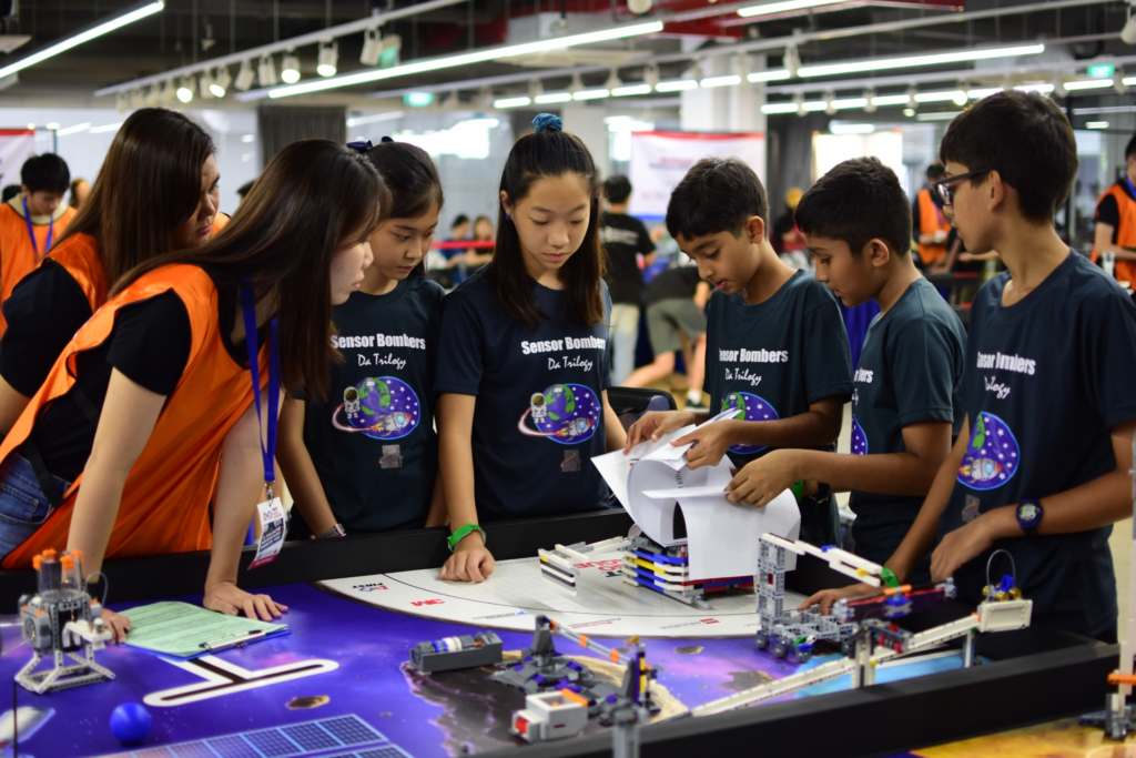 Team Sensor Bombers Da Trilogy presenting their space-themed LEGO robot project at FLL 2019, Canadian International School Singapore.