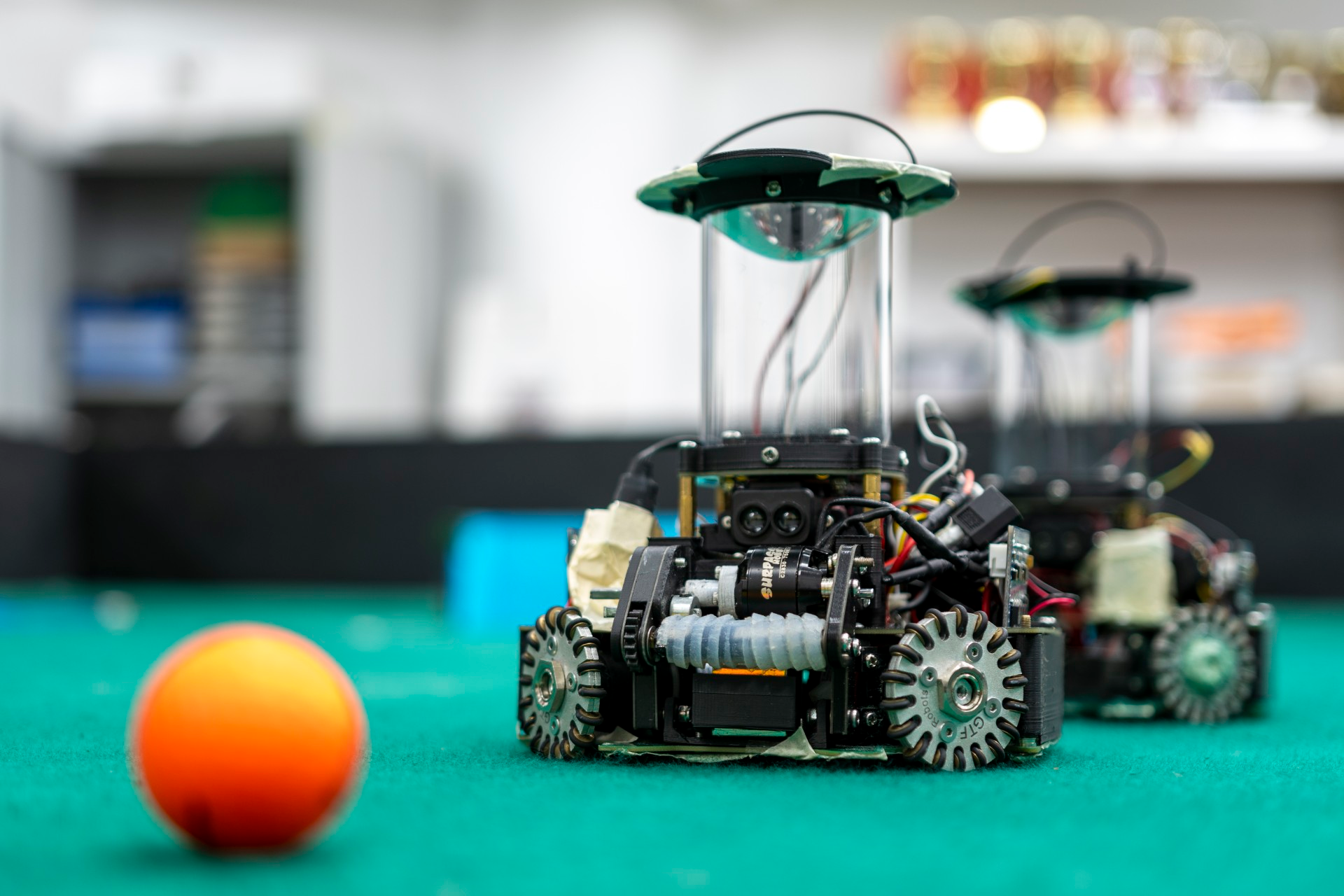 Team SOCKS’ autonomous soccer robots in a static shot on green turf, photographed in the Club Automatica room at RIJC.