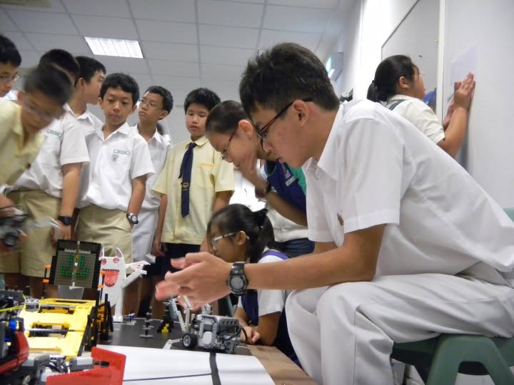Yak Jun Lun with students testing robots at Inter-Primary Infocomm Challenge